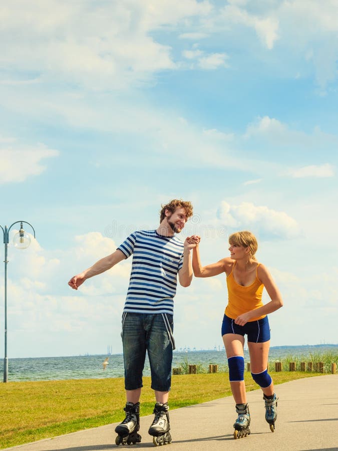 Jovem casal de patins ao ar livre imagem de stock royalty free