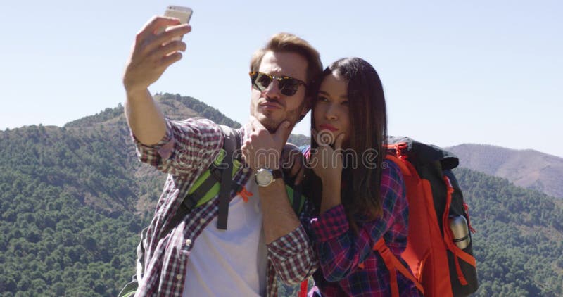 Jovem casal fazendo selfie enquanto caminhava