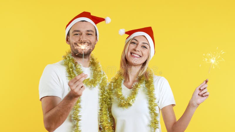 Jovem casal feliz carregando faíscas se divertindo e celebrando o ano novo