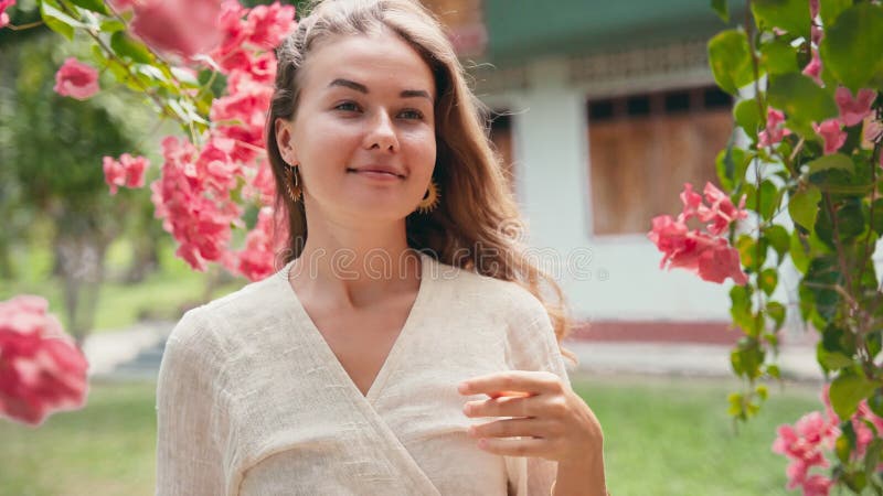 Jovem caucasiana alegre que se encontra no jardim das flores