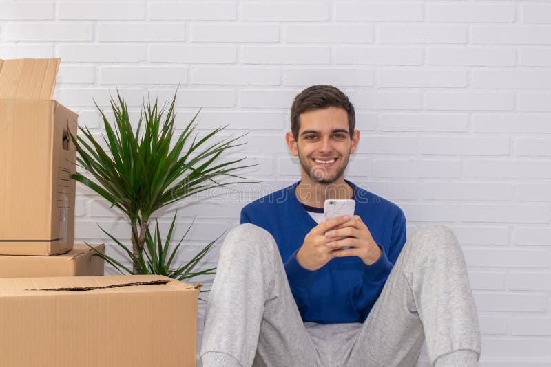 Jovem com caixas móveis em casa foto de stock