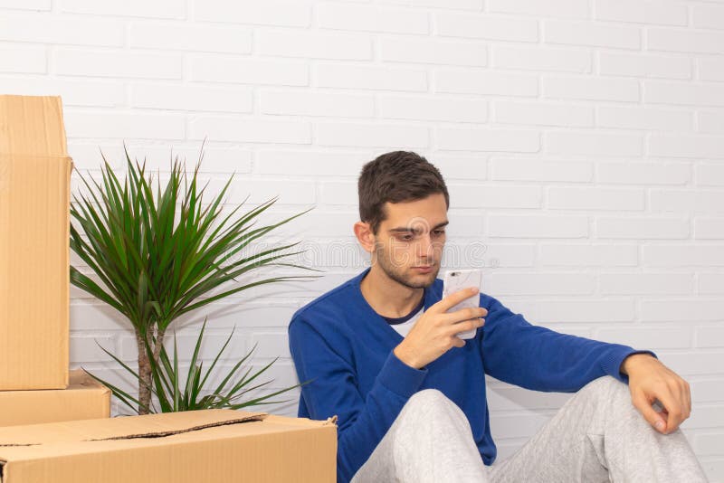 Jovem com caixas móveis no apartamento foto de stock royalty free