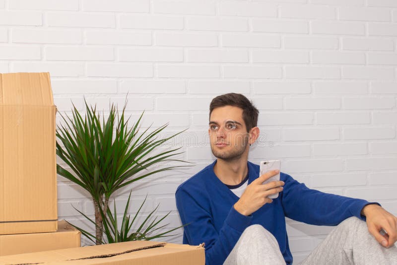 Jovem com caixas móveis no apartamento imagens de stock royalty free