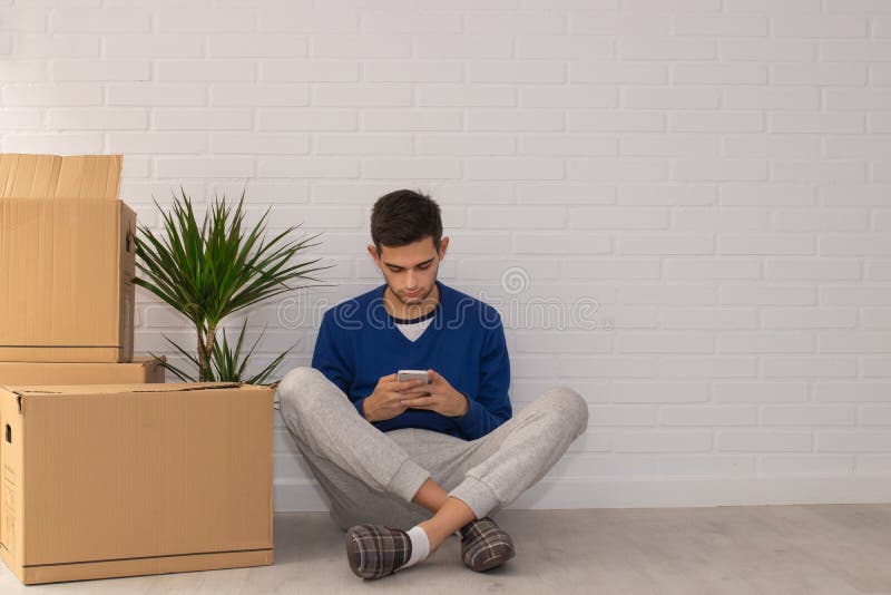 Jovem com caixas móveis no apartamento fotografia de stock