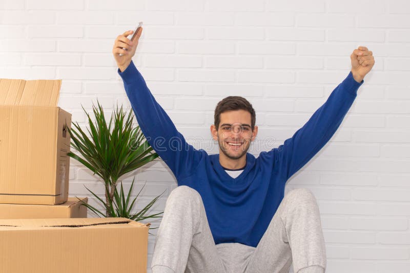 Jovem com caixas móveis no apartamento imagem de stock