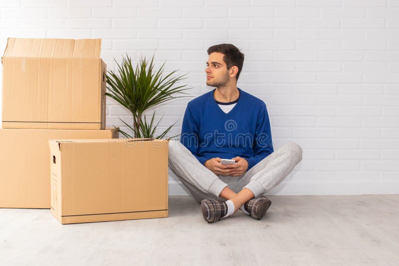 Jovem com caixas móveis no apartamento fotos de stock