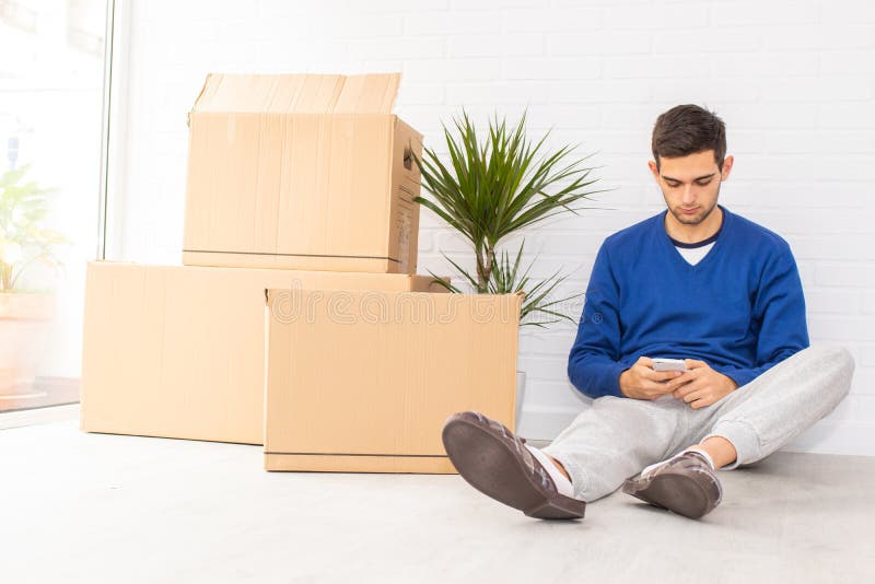 Jovem com caixas móveis no apartamento fotografia de stock royalty free