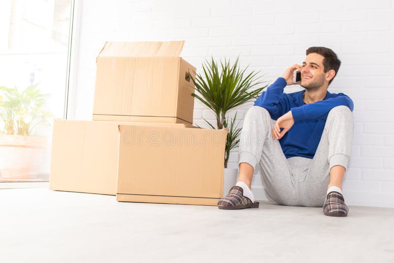 Jovem com caixas móveis no apartamento fotos de stock royalty free