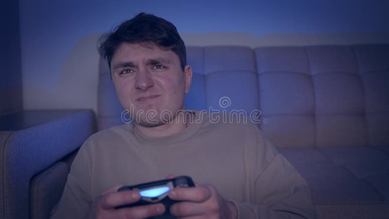 Jovem com controlador sentado no chão jogando videogame