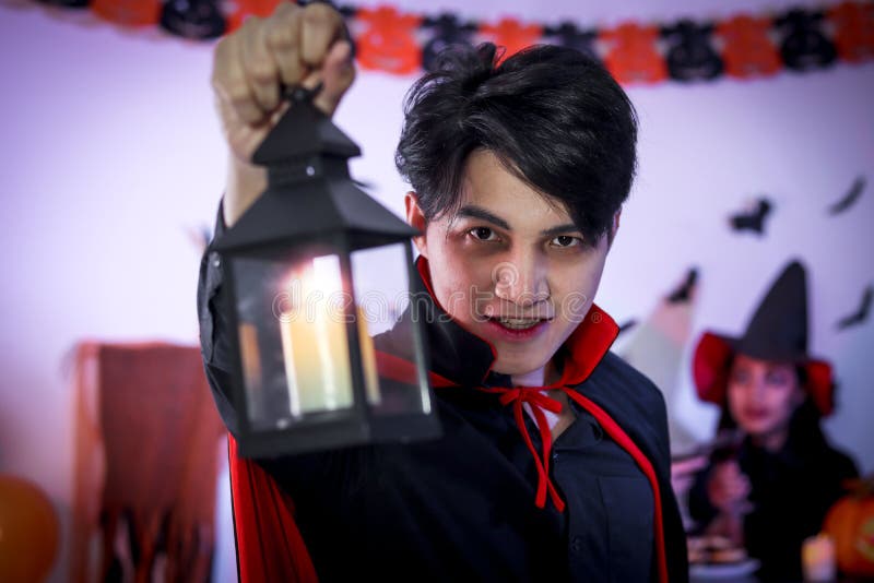 Homem bonito vestido com uma fantasia de drácula para o halloween. vampiro  atraente com velas