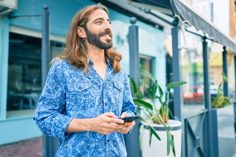 Jovem homem do Médio Oriente a usar smartphone na cidade imagens de stock royalty free