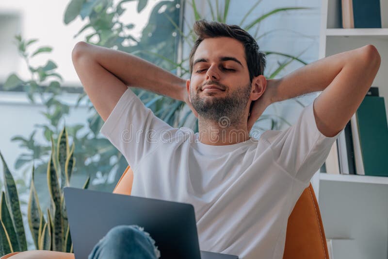 Jovem em casa com relaxamento do computador imagens de stock