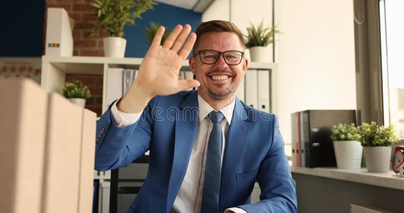 Jovem empresário sorridente e bem-sucedido com ondas de óculos para filmar 4k