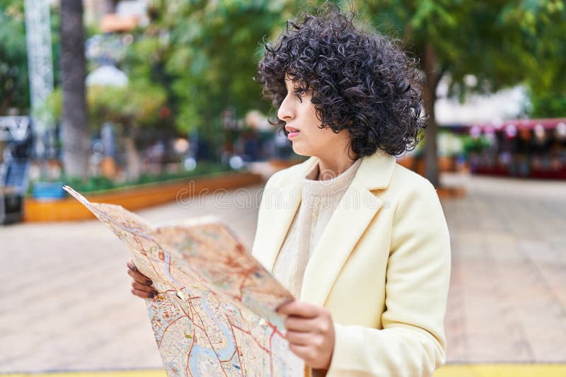 Jovem executiva do Médio Oriente a segurar um mapa da cidade num parque imagens de stock