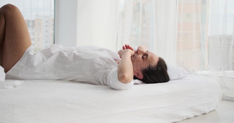 Jovem feliz deitada na cama