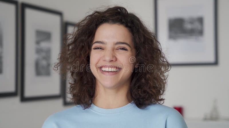 Jovem feliz e bonita hispânica rindo olhando para a câmera.