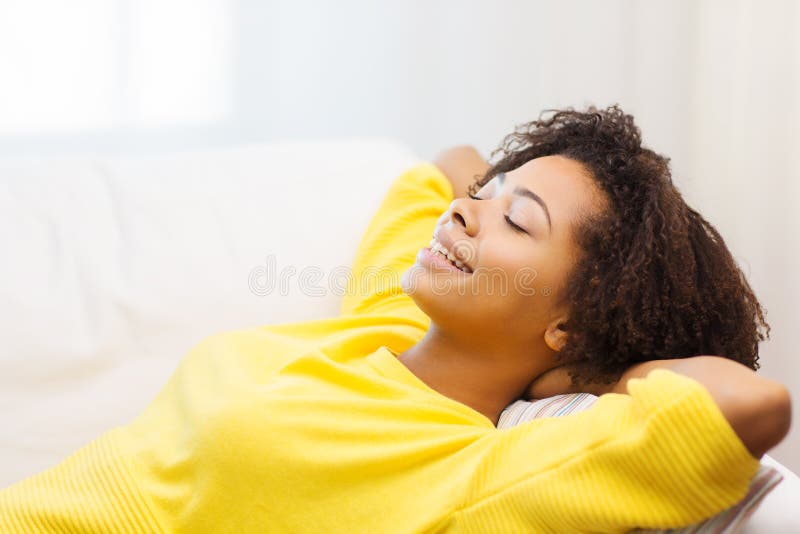 Jovem mulher africana feliz que relaxa em casa