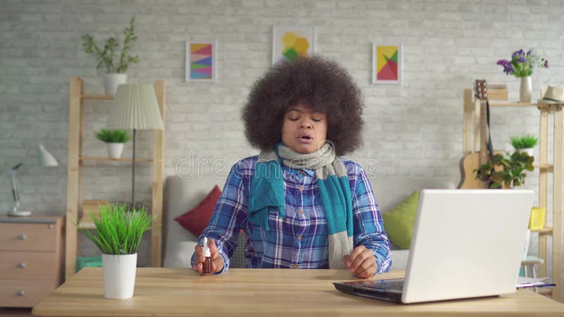 A jovem mulher afro-americano cansado do retrato com penteado do Afro com o lenço no pescoço é doente, pulverizador de nariz dos video estoque A jovem mulher afro-americano cansado do retrato com penteado do Afro com o lenço no pescoço é doente, pulverizador de nariz dos video estoque