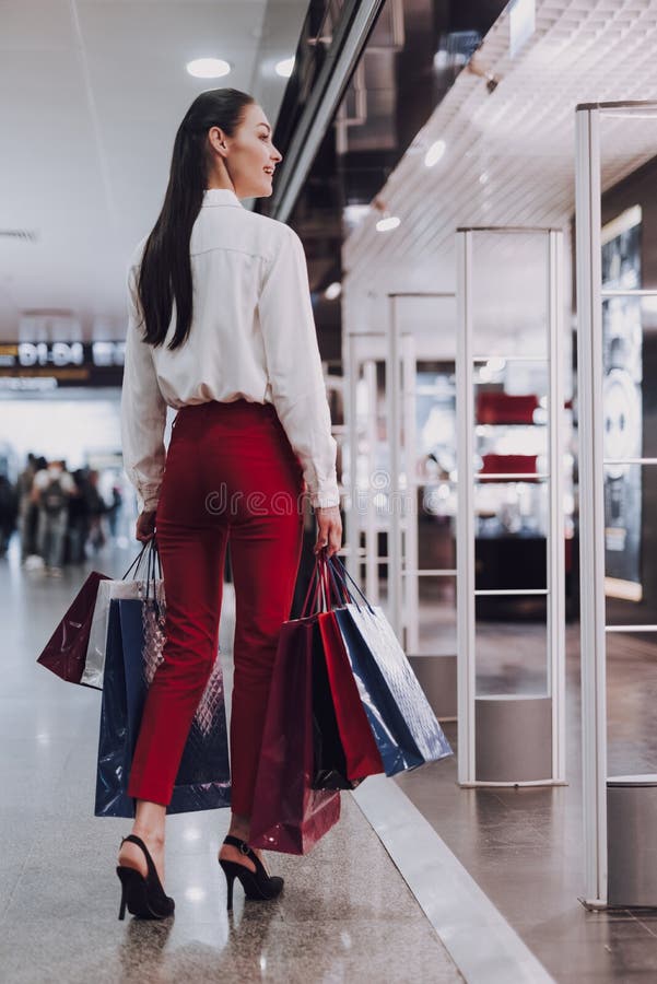 A jovem mulher alegre está comprando antes do voo imagens de stock A jovem mulher alegre está comprando antes do voo imagens de stock