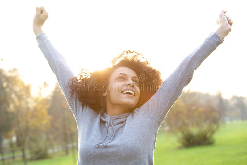 Portrait of a cheerful young woman smiling with arms raised. Portrait of a cheerful young woman smiling with arms raised