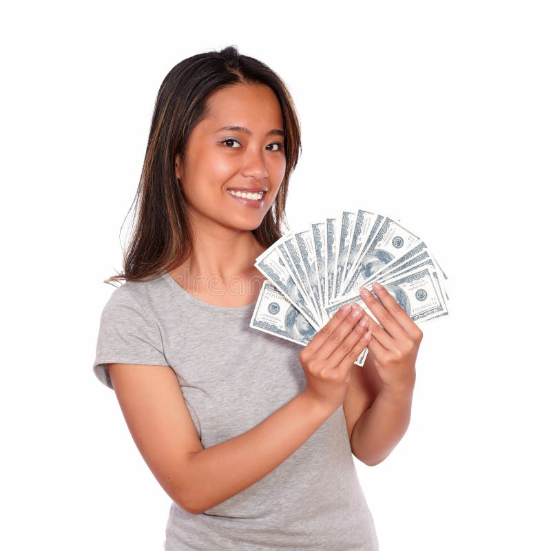 Portrait of an asiatic young woman holding cash money while is looking at you against white background. Portrait of an asiatic young woman holding cash money while is looking at you against white background