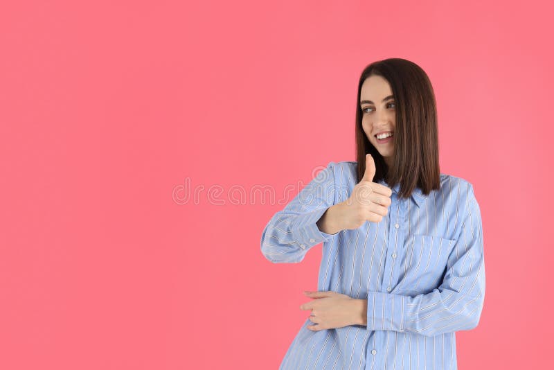 Jovem mulher atraente camisa de fundo rosa foto de stock