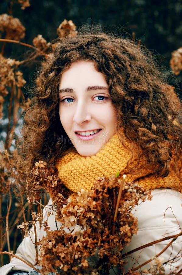 Jovem mulher atrativa com fluxo secado próximo da hortênsia do cabelo encaracolado imagem de stock royalty free Jovem mulher atrativa com fluxo secado próximo da hortênsia do cabelo encaracolado imagem de stock royalty free
