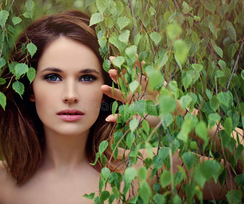 Jovem mulher bonita com as folhas verdes do vidoeiro imagens de stock royalty free Jovem mulher bonita com as folhas verdes do vidoeiro imagens de stock royalty free