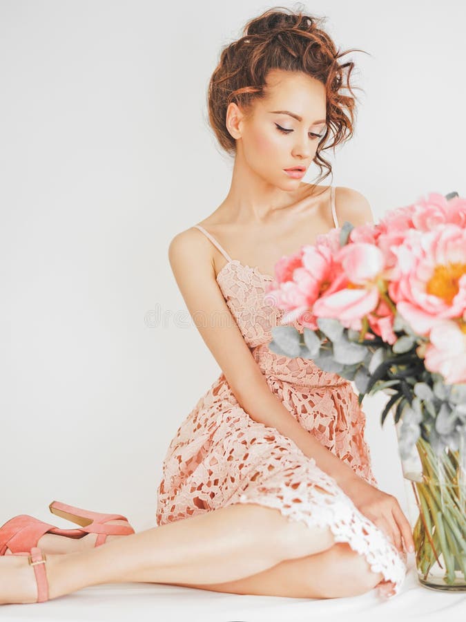 Home stylish fashion photo of beautiful young woman in lace dress with big bouquet of peony. Holidays and Events. Valentine`s Day. Spring blossom. Summer season. Home stylish fashion photo of beautiful young woman in lace dress with big bouquet of peony. Holidays and Events. Valentine`s Day. Spring blossom. Summer season.