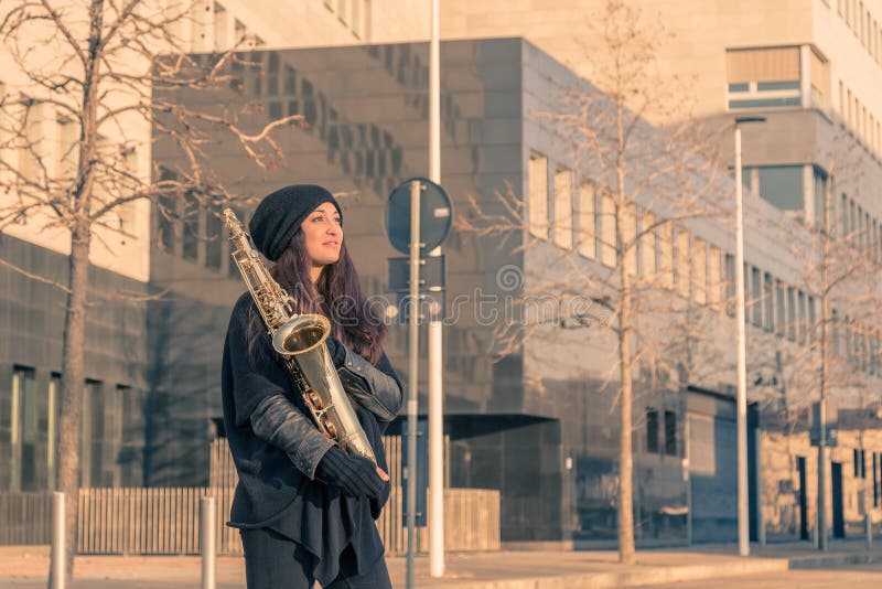 Jovem mulher bonita com seu saxofone imagem de stock royalty free