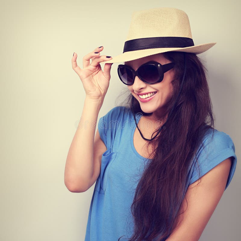 A jovem mulher bonita de sorriso com chapéu de palha e a forma expõem ao sol o gla fotografia de stock A jovem mulher bonita de sorriso com chapéu de palha e a forma expõem ao sol o gla fotografia de stock