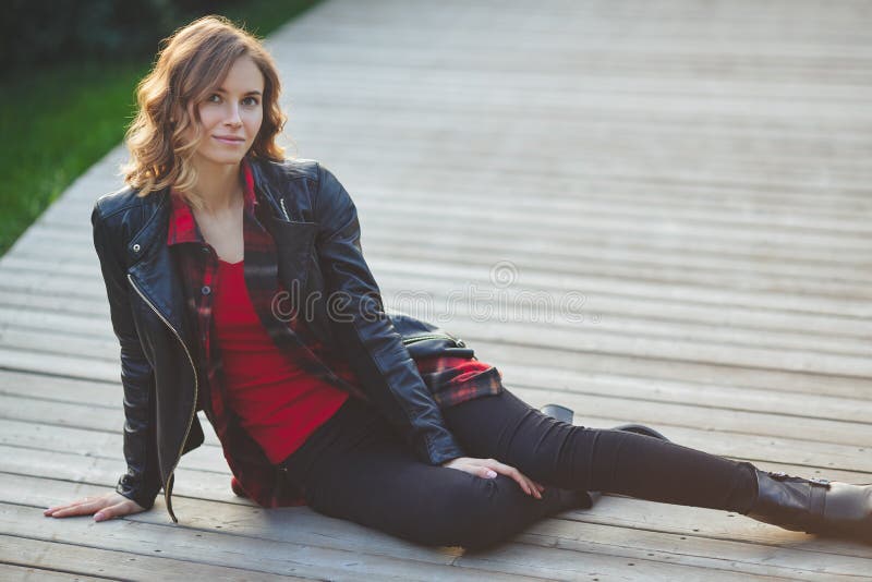 Jovem mulher bonita no casaco de cabedal preto Retrato ao ar livre foto de stock Jovem mulher bonita no casaco de cabedal preto Retrato ao ar livre foto de stock