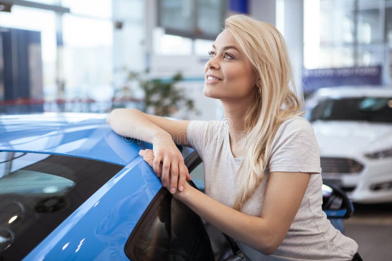 Jovem mulher bonita que compra o carro novo no negócio imagem de stock Jovem mulher bonita que compra o carro novo no negócio imagem de stock