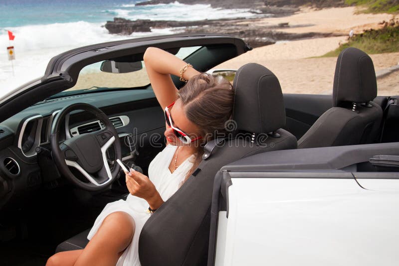 Jovem mulher bonita que descansa em seu carro imagem de stock royalty free Jovem mulher bonita que descansa em seu carro imagem de stock royalty free