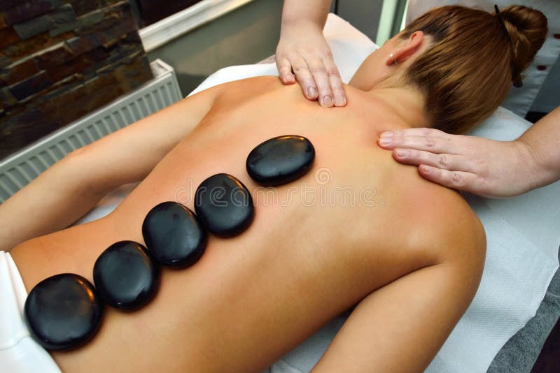 Jovem mulher bonita que encontra-se para baixo quando o terapeuta da massagem for mas fotografia de stock Jovem mulher bonita que encontra-se para baixo quando o terapeuta da massagem for mas fotografia de stock