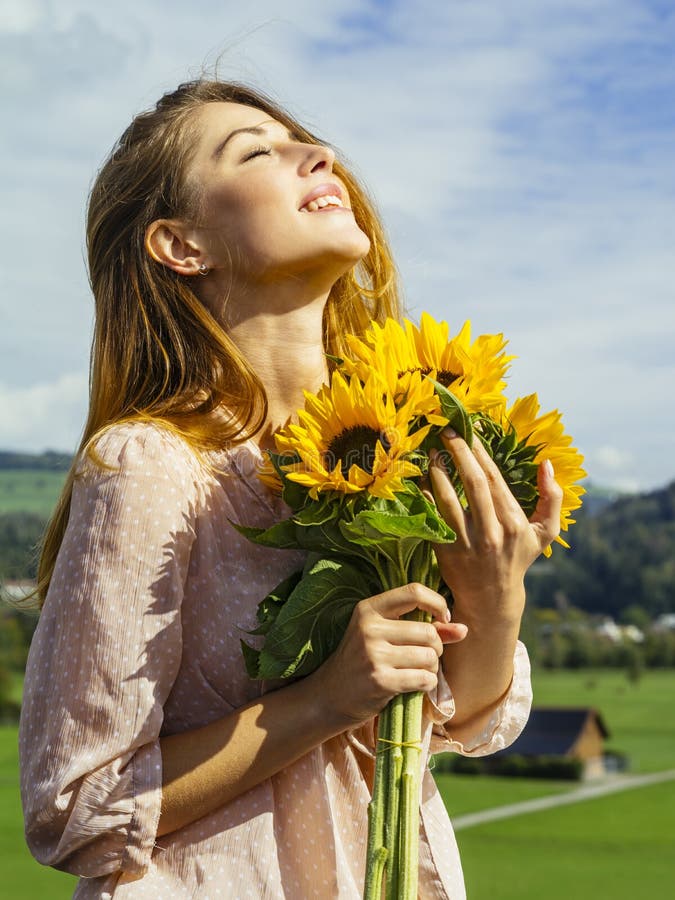 Jovem mulher bonita que guarda girassóis foto de stock Jovem mulher bonita que guarda girassóis foto de stock