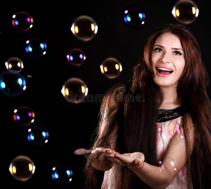 Jovem mulher bonita que joga com bolhas de sabão fotografia de stock royalty free Jovem mulher bonita que joga com bolhas de sabão fotografia de stock royalty free
