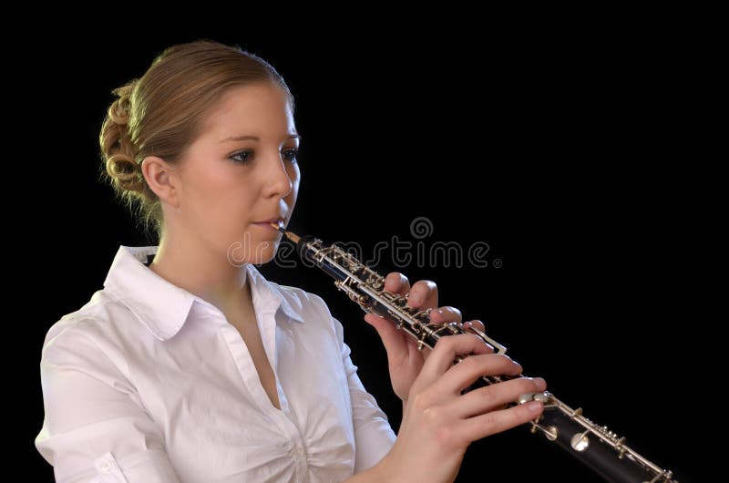 Jovem mulher bonita que joga o oboé imagem de stock Jovem mulher bonita que joga o oboé imagem de stock