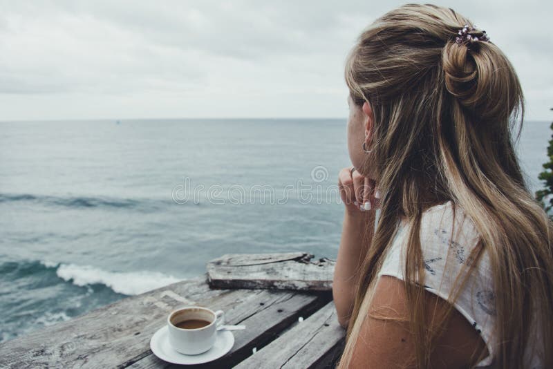Jovem mulher café que relaxa, beber e apreciando a vista do oceano, Bali indonésia foto de stock Jovem mulher café que relaxa, beber e apreciando a vista do oceano, Bali indonésia foto de stock