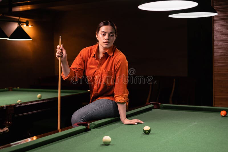 Mulher bonita no bar ao lado da mesa de sinuca, gente jogando