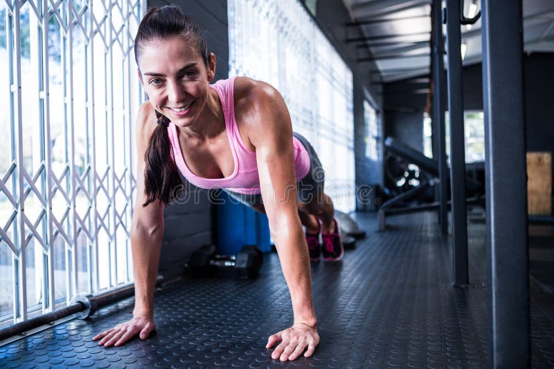 Jovem mulher de sorriso no gym fotografia de stock Jovem mulher de sorriso no gym fotografia de stock