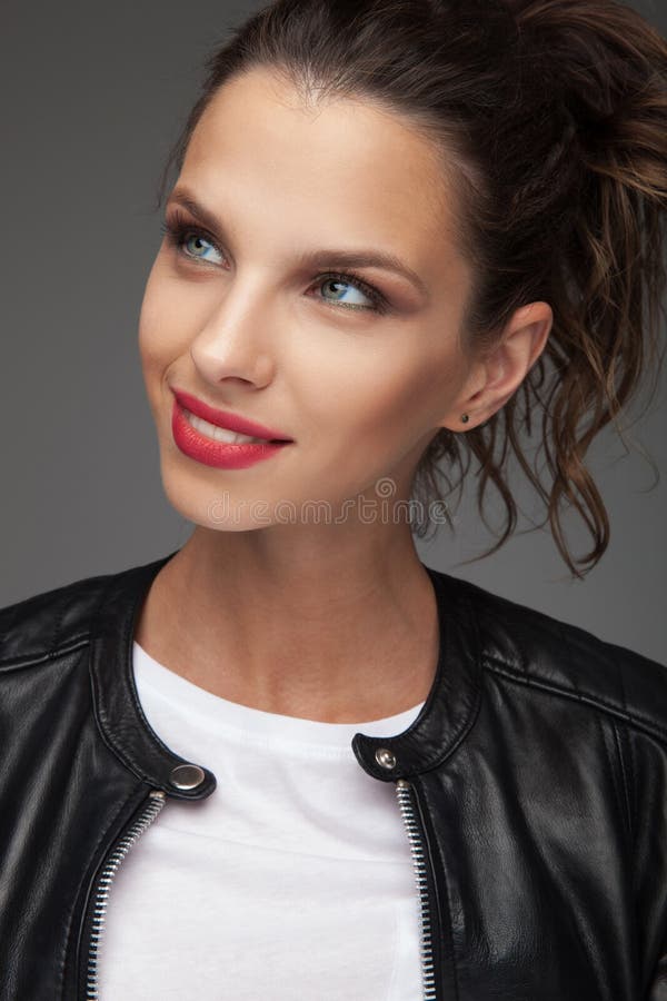 A jovem mulher de sorriso olha acima a um lado imagem de stock A jovem mulher de sorriso olha acima a um lado imagem de stock