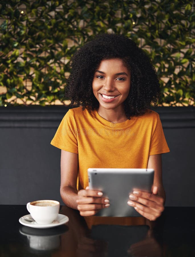 Jovem mulher de sorriso que guarda a tabuleta digital à disposição foto de stock Jovem mulher de sorriso que guarda a tabuleta digital à disposição foto de stock