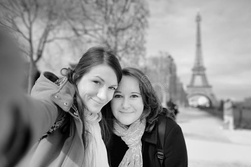 Jovem mulher dois que toma um selfie perto da torre Eiffel fotografia de stock royalty free Jovem mulher dois que toma um selfie perto da torre Eiffel fotografia de stock royalty free