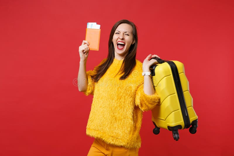 Jovem mulher extático feliz na camiseta amarela da pele que grita, mala de viagem da terra arrendada, bilhete da passagem de emba fotografia de stock royalty free Jovem mulher extático feliz na camiseta amarela da pele que grita, mala de viagem da terra arrendada, bilhete da passagem de emba fotografia de stock royalty free