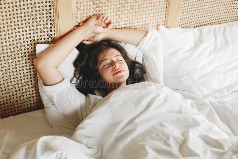 Jovem mulher feliz bonita que encontra-se na cama na manh? na sala de hotel ou no quarto da casa Menina moreno à moda no sono bra imagem de stock Jovem mulher feliz bonita que encontra-se na cama na manh? na sala de hotel ou no quarto da casa Menina moreno à moda no sono bra imagem de stock