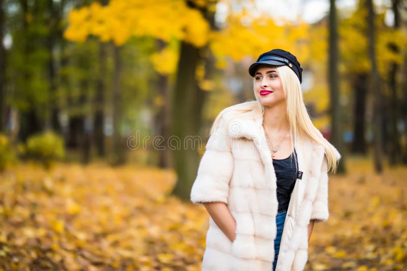 Jovem mulher feliz bonita que tem o divertimento com as folhas no parque do outono fotos de stock Jovem mulher feliz bonita que tem o divertimento com as folhas no parque do outono fotos de stock
