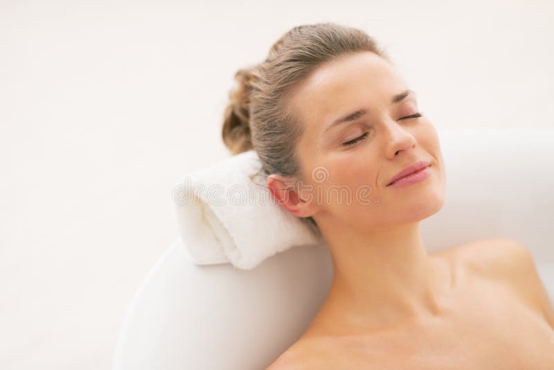 Jovem mulher feliz que relaxa na banheira foto de stock royalty free Jovem mulher feliz que relaxa na banheira foto de stock royalty free