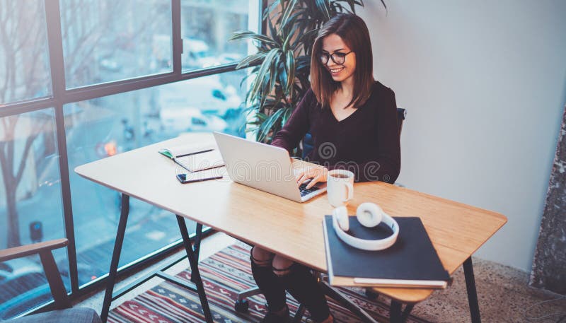 Jovem mulher feliz que usa o portátil móvel para fazer a conversação do negócio com os sócios durante o processo do trabalho no e fotografia de stock royalty free Jovem mulher feliz que usa o portátil móvel para fazer a conversação do negócio com os sócios durante o processo do trabalho no e fotografia de stock royalty free