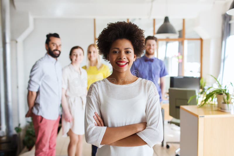 Jovem mulher feliz sobre a equipe criativa no escritório imagem de stock Jovem mulher feliz sobre a equipe criativa no escritório imagem de stock